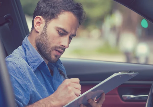 Concepto de propiedad del transporte. Hombre dentro de coche nuevo lectura firma documentos — Foto de Stock