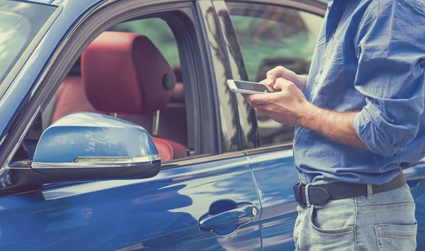 Aplicaciones de teléfono móvil para propietarios de automóviles. Hombre usando el teléfono inteligente para comprobar el estado del coche de control — Foto de Stock