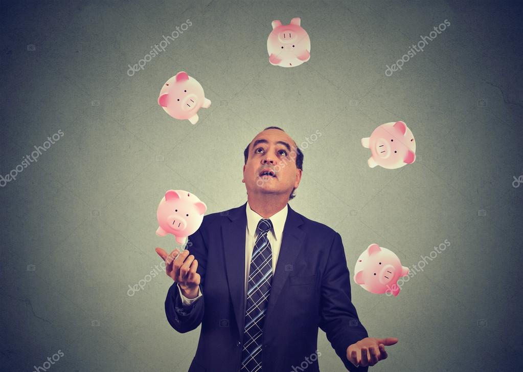 Herunterladen - Geschäftsmann mittleren Alters jongliert mit Sparschwein — Stockbild Geschäftsmann mittleren Alters jongliert mit Sparschwein — Stockfoto