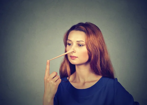 Frau mit langer Nase isoliert auf grauem Wandhintergrund. Lügenkonzept — Stockfoto