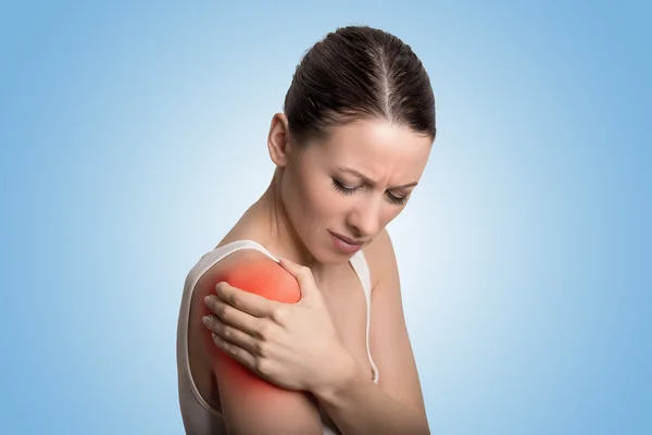 Articulación lesionada. Mujer joven con dolor en el hombro doloroso de color rojo . — Foto de Stock