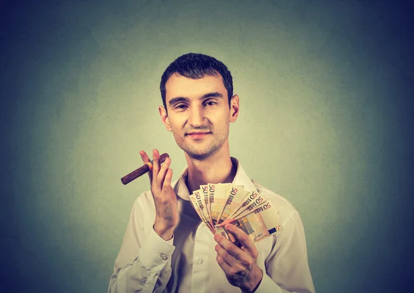 Щасливий молодий впевнений чоловік з євро банкнотами гроші і сигари — стокове фото