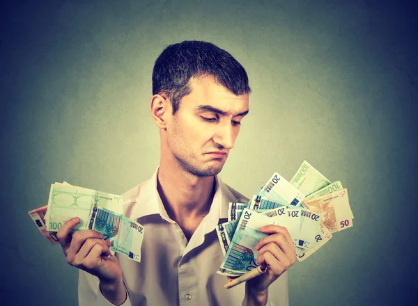 Nespokojený mladý muž s penězi — Stock fotografie