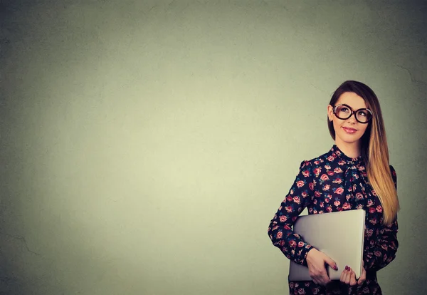 Beautiful happy woman standing with laptop over gray wall background — Stock Photo, Image