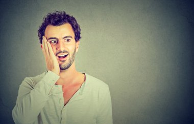 Wow. Man looking excited holding his mouth opened, shocked surprised 