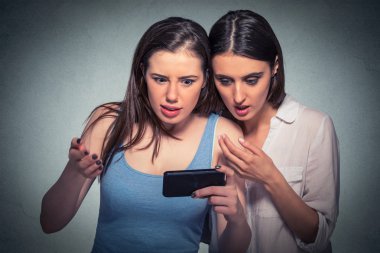 İki sürpriz kız cep telefonu bakarak son dedikodu haberleri tartışıyor