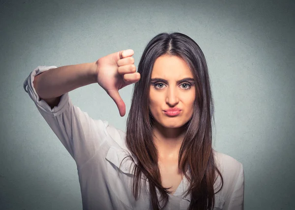 Mujer infeliz dando el pulgar hacia abajo gesto mirando con expresión negativa — Foto de Stock