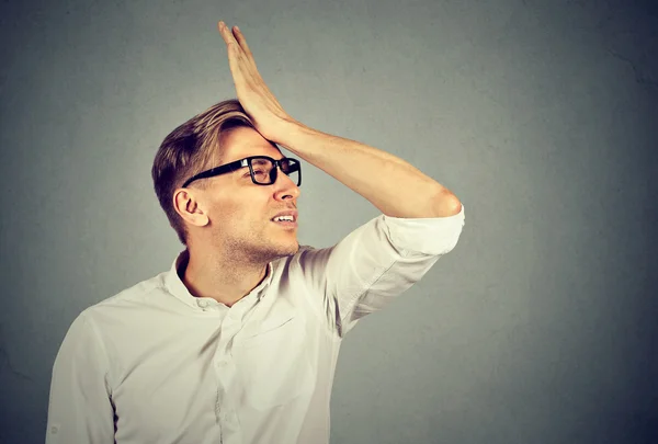 Silly man slapping hand on head having duh moment — Stock Photo, Image