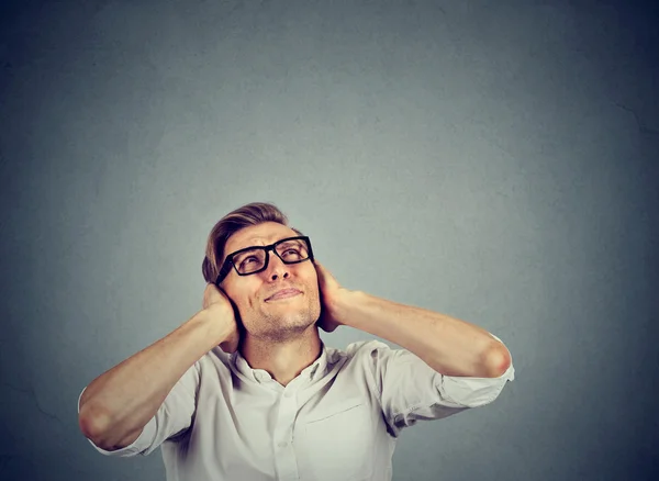 Irritado estressado homem cobrindo ouvidos olhando para cima parar de fazer barulho — Fotografia de Stock