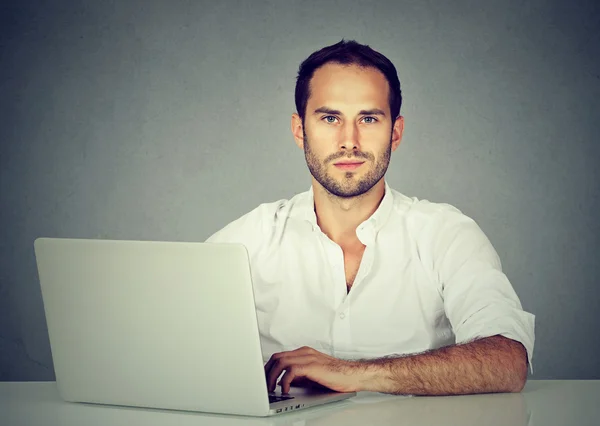 Mosolygó fiatal üzletember használ egy laptop — Stock Fotó