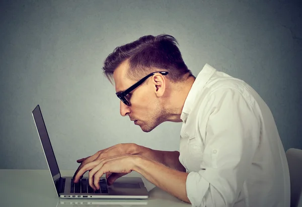 Jovem homem de óculos trabalhando no computador sentado na mesa — Fotografia de Stock