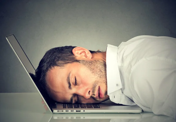 Деловой человек спит на ноутбуке в своем офисе — стоковое фото