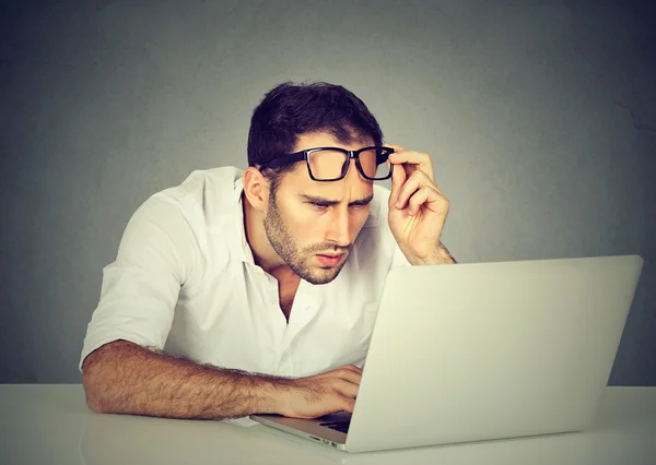 ノート パソコンで混乱の視力問題を抱えて眼鏡の男 — ストック写真