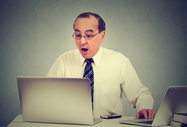 Shocked man sitting in front of laptop computer — Stock Photo, Image