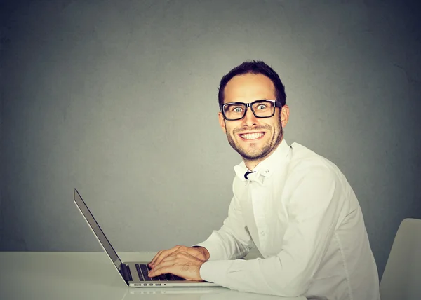 Jovem sorridente usando um laptop — Fotografia de Stock