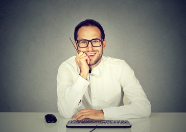 Bilgisayar klavye önünde oturan genç yakışıklı adam gülümseyen