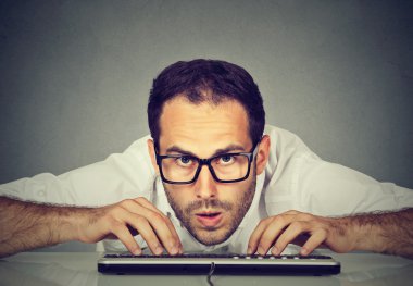 Çılgın görünümlü nerdy adam klavyede yazarak