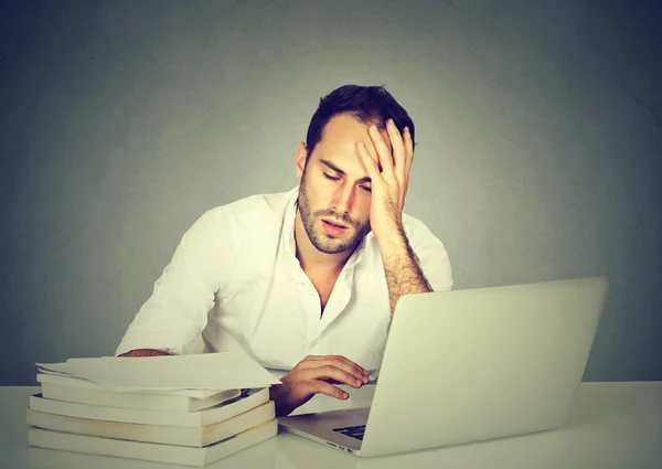 Fatigué somnolent homme assis au bureau avec des livres ordinateur portable — Photo