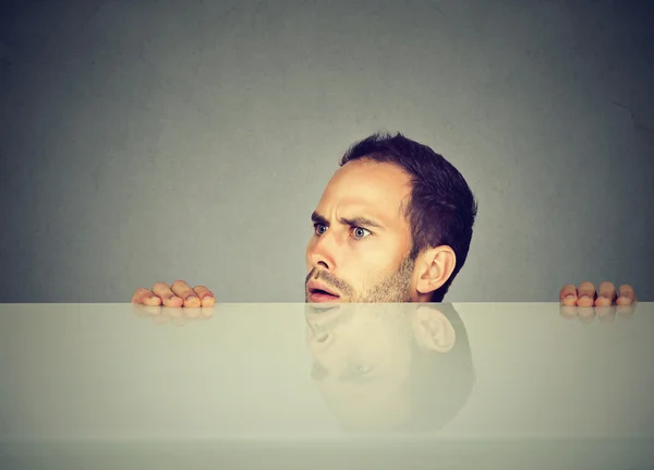 Homme soupçonneux regardant sous la table — Photo