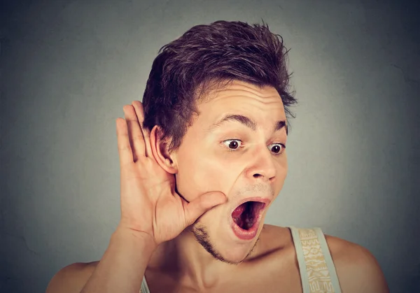 Sorprendido hombre entrometido mano a oreja gesto escuchando cuidadosamente chismes —  Fotos de Stock