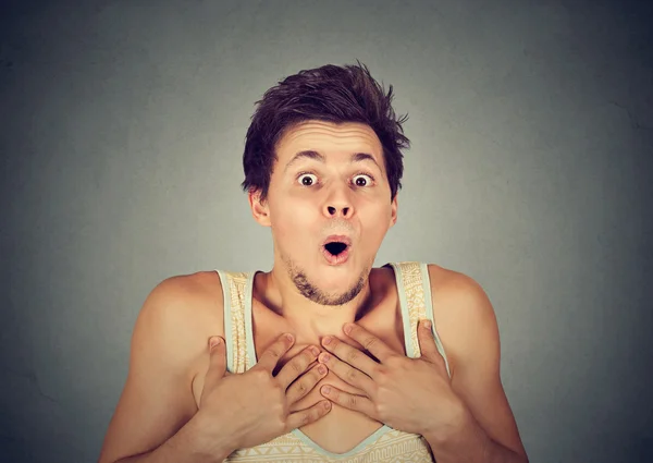 Shocked surprised young man in full disbelief with hands on chest — Stock Photo, Image