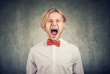 Portrait of an angry screaming young man  clipart
