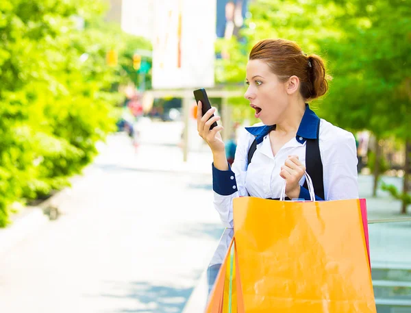 Mulher comprador chocado olhando para seu telefone inteligente — Fotografia de Stock