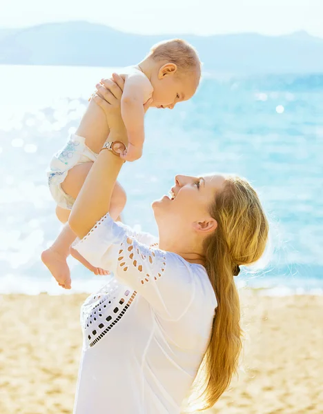 Mãe feliz e seu filho bebê na praia — Fotografia de Stock