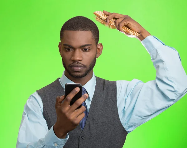 Dirigente aziendale leggere notizie su smart phone, pettinando la sua hai — Foto Stock