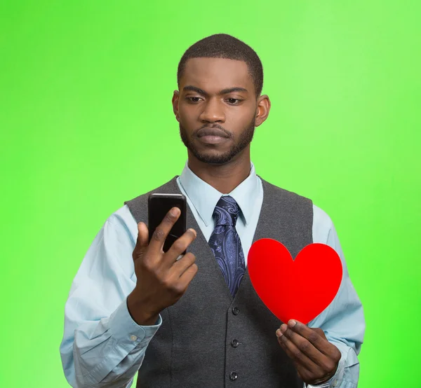 Jovem com telefone inteligente e coração vermelho — Fotografia de Stock