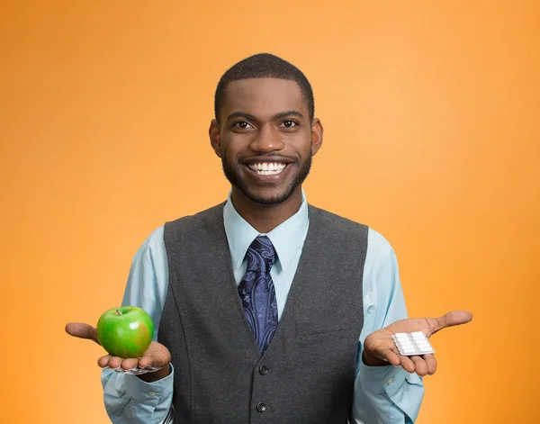 Hombre sosteniendo manzana fresca verde en una mano, pastillas, vitaminas en un — Foto de Stock