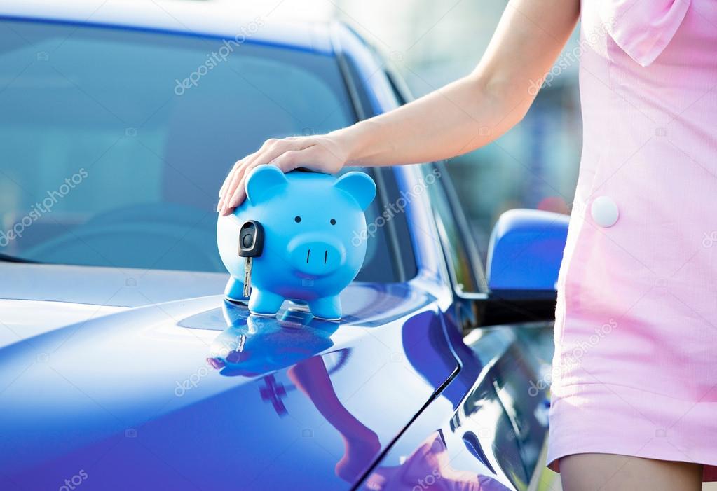 Cropped image woman customer, new car, piggy bank, key on hood