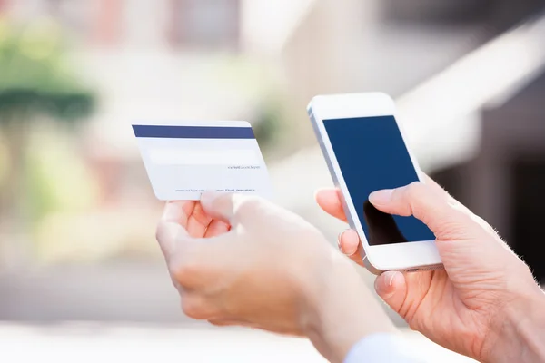 Manos de mujer sosteniendo tarjeta de crédito y usando celular, teléfono inteligente —  Fotos de Stock