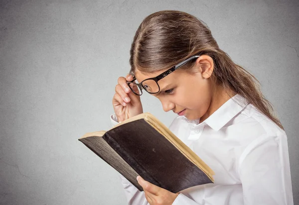 Menina ler livro, tem pobre, má visão — Fotografia de Stock