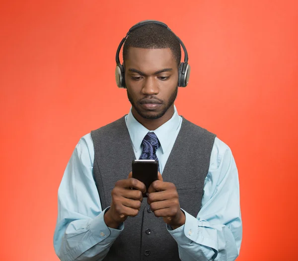 Man met hoofdtelefoon surfen op internet op smartphone — Stockfoto