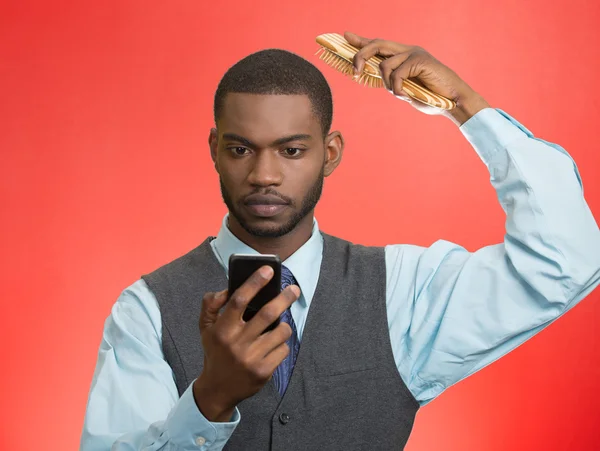 Ο άνθρωπος των επιχειρήσεων, ανάγνωση ειδήσεων σχετικά με έξυπνο τηλέφωνο, χτενίζει τα μαλλιά — Φωτογραφία Αρχείου