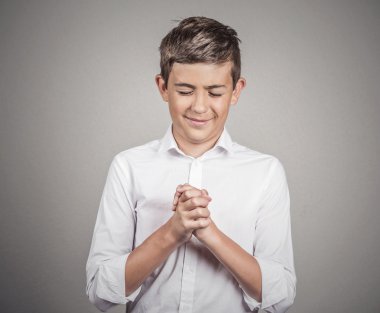 Man, teenager praying, arms clasped, eyes closed clipart