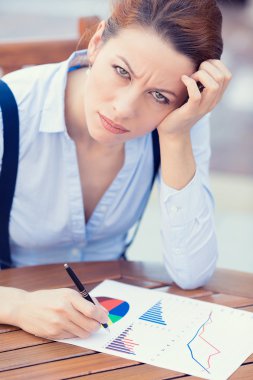 Unhappy business woman looking displeased working on financial report 
