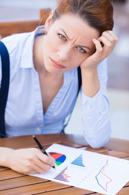 Unhappy business woman looking displeased working on financial report 
