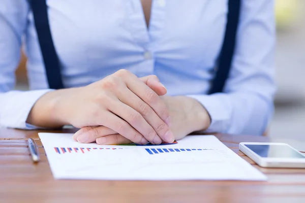Manos de mujer de negocios sentadas a la mesa frente al documento del informe financiero con gráficos — Foto de Stock