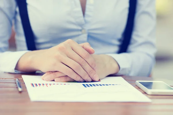 Zakenvrouw handen zitten aan tafel tegenover financieel verslag document met grafieken — Stockfoto