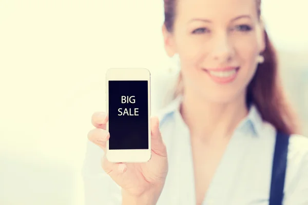 Ung kvinna visar smarta mobiltelefon med stor försäljning tecken på skärmen — Stockfoto