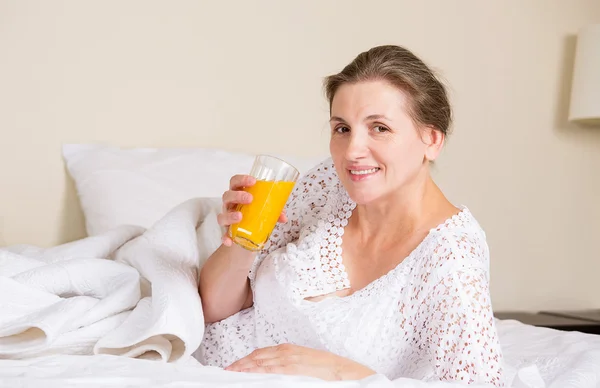 Beautiful woman having breakfast, in bed, bedroom of her house — Stock Photo, Image