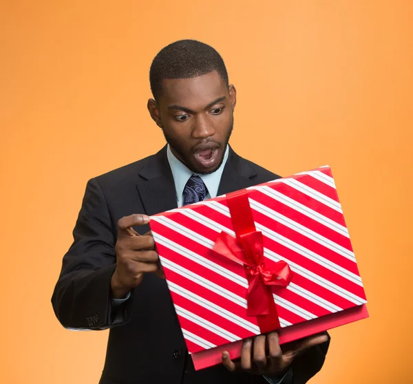 Surprised businessman about to open unwrap red gift box — Stock Photo, Image