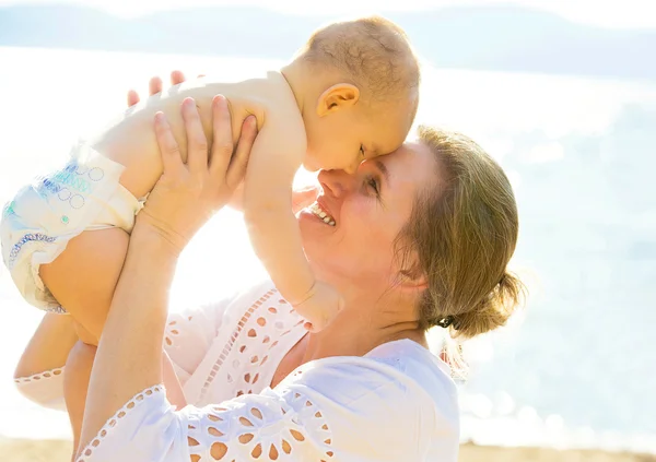 Glückliche Großmutter lächelnd Baby-Enkel, Kopf an Kopf isoliert See, Meer Hintergrund — Stockfoto