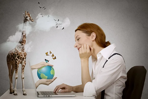 Dreaming woman sitting in front of computer, hands with earth coming from laptop screen — Stock Photo, Image