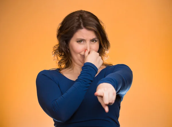 Woman pinches nose pointing at you with finger, you stink — Stock Photo, Image