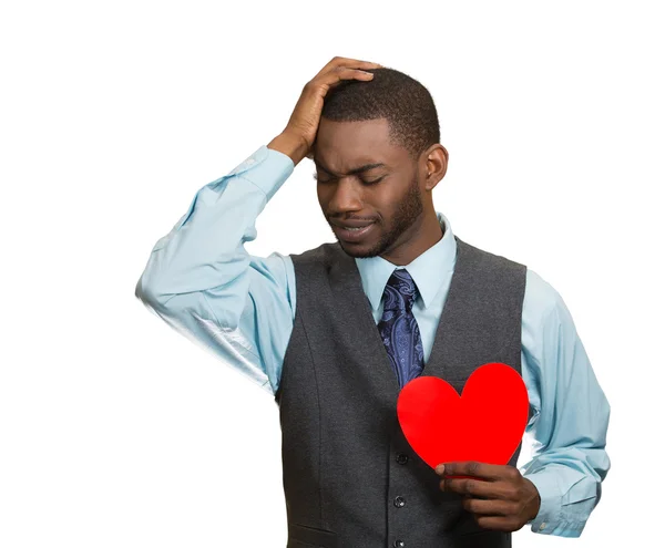 Heartbroken man, holding red heart in hand — Stock Photo, Image