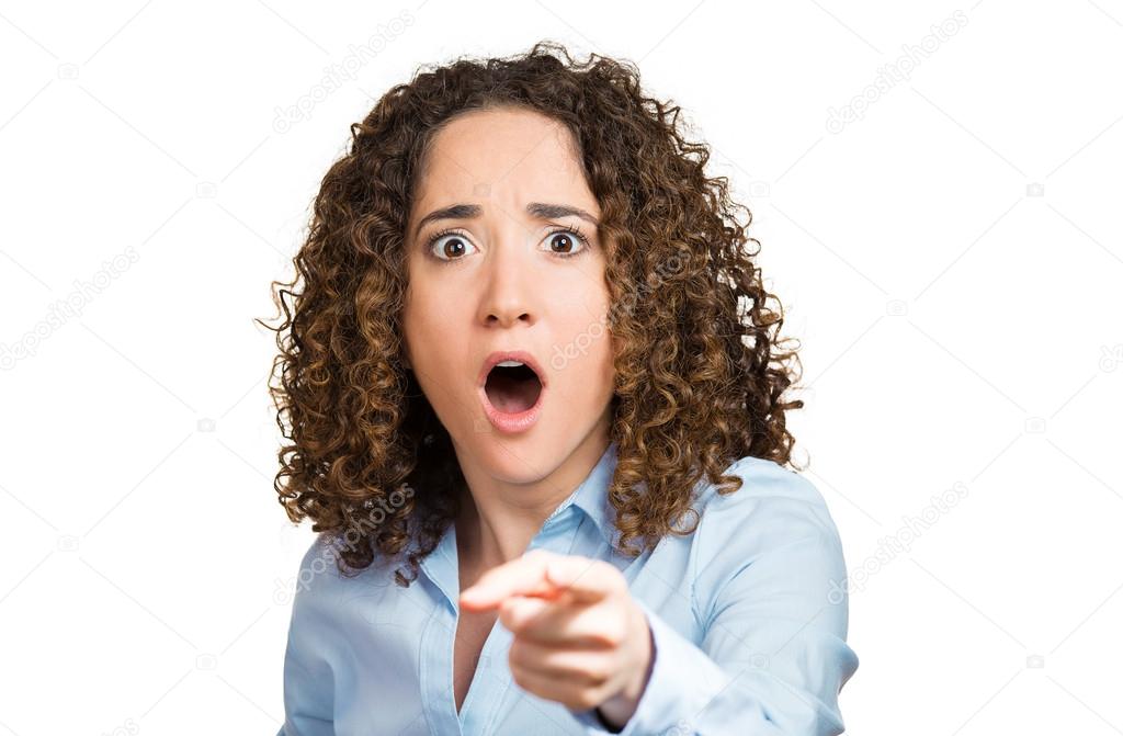 Surprised, shocked young woman pointing with finger at something