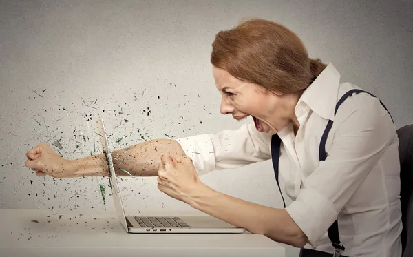 Woedend zakenvrouw gooit een punch in computer, schreeuwen — Stockfoto